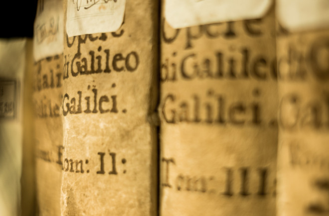 Close-up of aged book spines showing Galileo's collected works