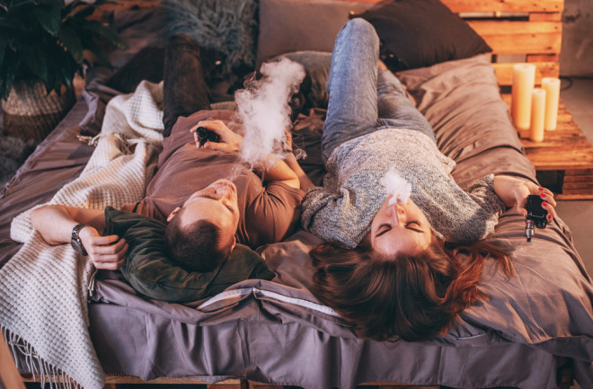 a couple is vaping in bed - shutterstock 1328801564