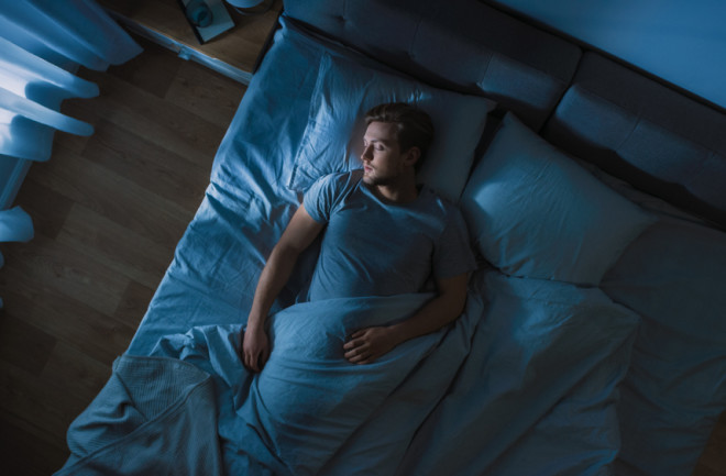 man sleeping in bed alone - shutterstock