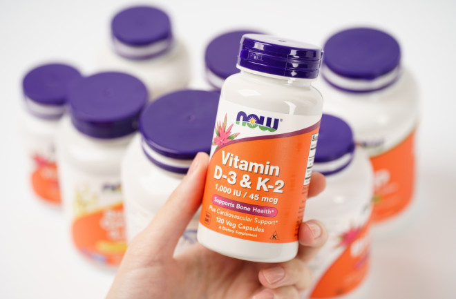 Dnipro, Ukraine -09.09.2023: Bottle of vitamin D-3, K-2 by NOW in woman hand. Now Foods, D-3, K-2 1,000 IU 45 mcg. Vegetarian food supplements. 